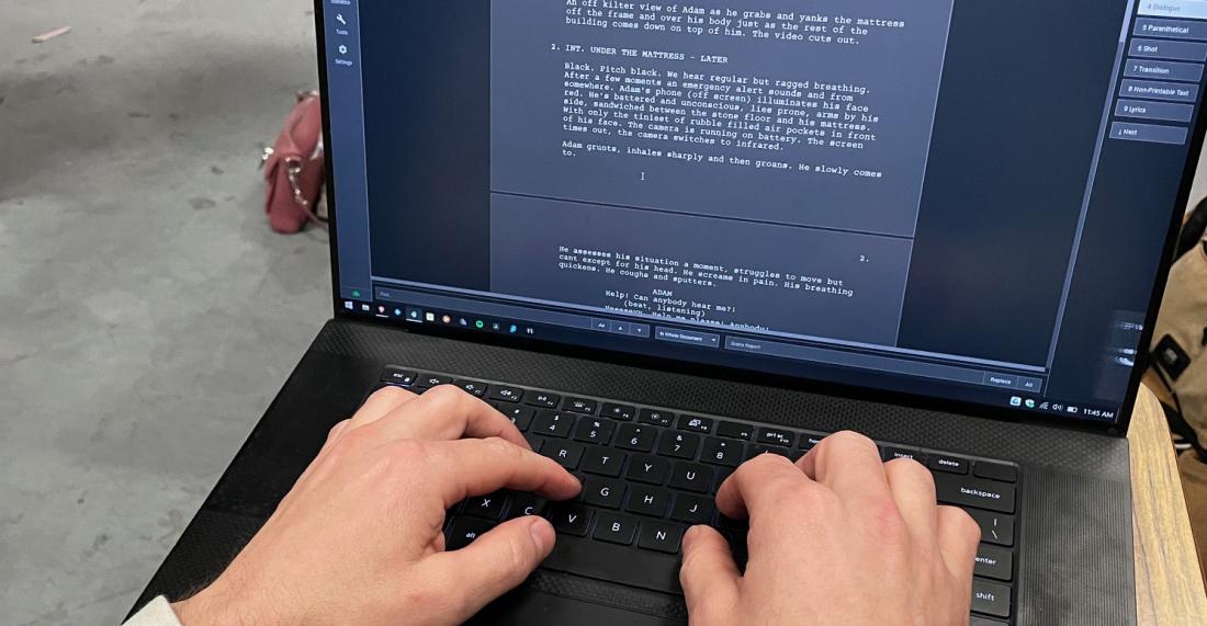An open computer with a screenplay being typed on it. 