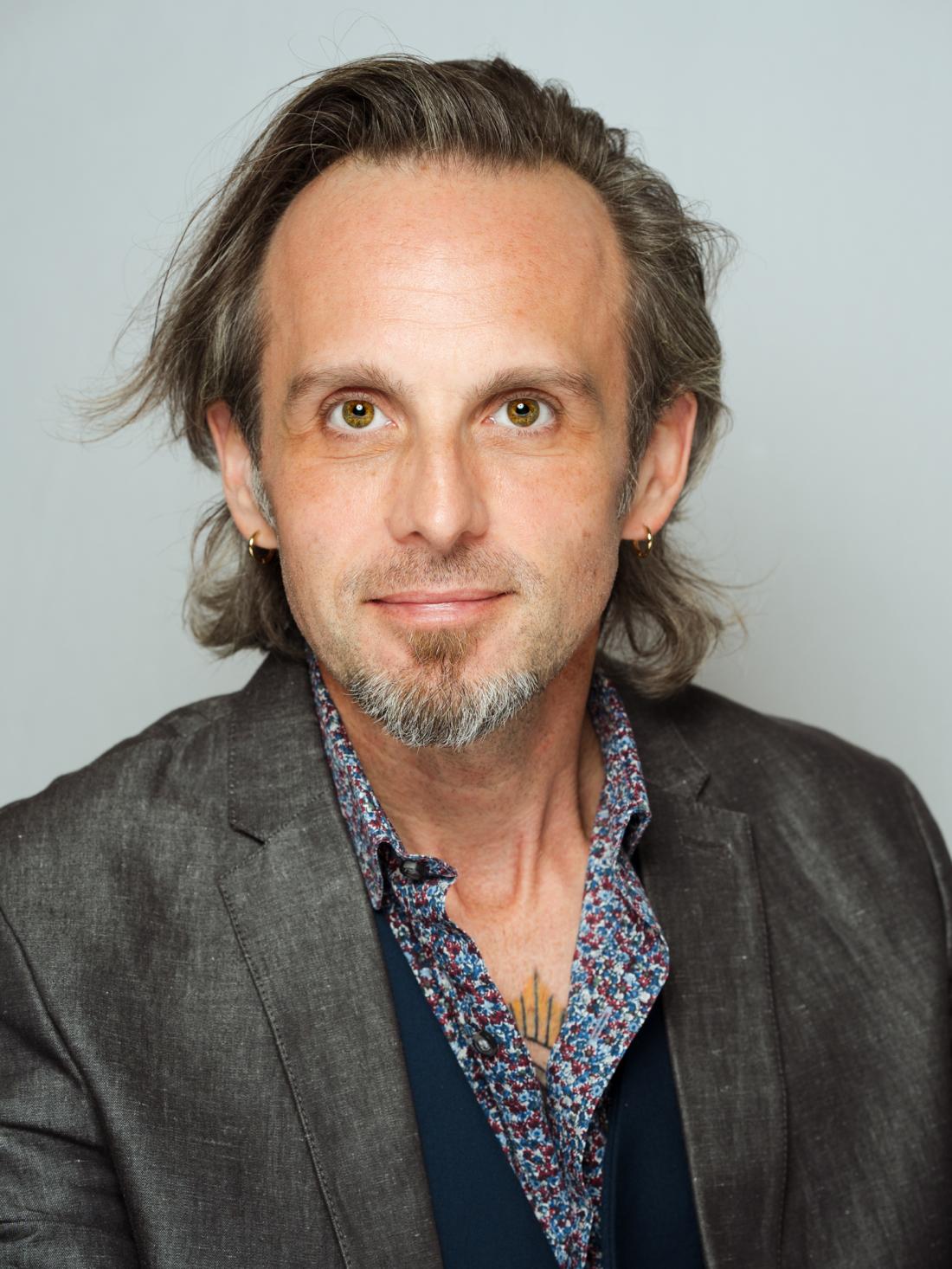 Headshot of LACC Audio Engineer, Juan "Stu" Suarez against a white backdrop