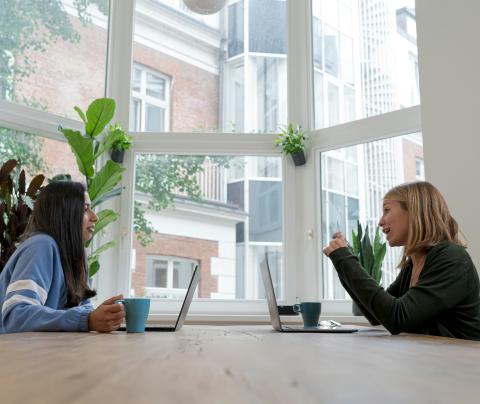 Two people talking across table
